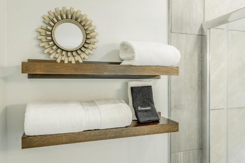 a bathroom with wooden shelves with towels and a mirror at 05 The Finn Room - A PMI Scenic City Vacation Rental in Chattanooga