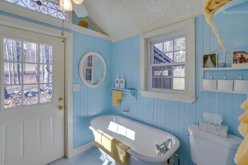 Baño azul con bañera y lavamanos en Cozy Fiddlers Rest Cabin 11 Miles to Skiing!, en Bernardston