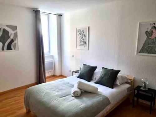 a bedroom with a large bed with green pillows at Le St Apollinaire n°2-Ma Cabotte in Meximieux