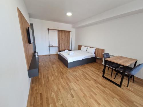 a bedroom with a bed and a table and a television at Luxury Apartment IVA III in Skopje