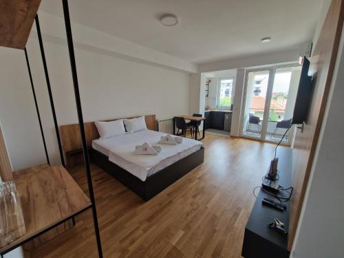 a bedroom with a bed and a room with a table at Luxury Apartment IVA III in Skopje