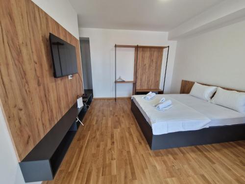 a hotel room with a bed and a flat screen tv at Luxury Apartment IVA III in Skopje