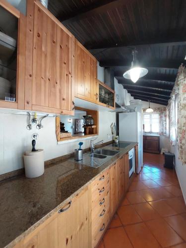 a kitchen with wooden cabinets and a sink at casa do vale - Lagoa de Albufeira in Lagoa de Albufeira