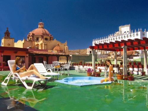 dos mujeres sentadas en sillas en una piscina en Hotel Posada Santa Fe en Guanajuato