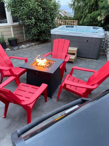 Eagle's View Penthouse في فيكتوريا: مجموعة من الكراسي الحمراء وطاولة مع النار