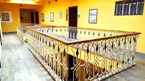 a metal railing in a room with a yellow wall at Hotel Posada Santa Fe in Guanajuato