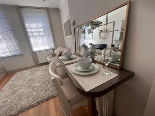 a dining room table with chairs and a mirror at Central private 1 bed flat in Reading