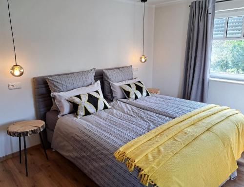 ein Schlafzimmer mit einem großen Bett und einer gelben Decke in der Unterkunft Design Apartment an der Via Claudia 