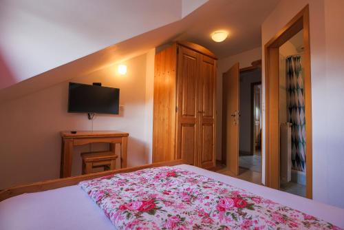 a bedroom with a bed with a pink floral blanket at Domačija Malnarjevi in Villa Slavina