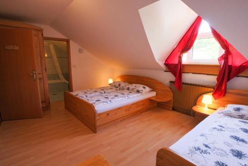 a small room with two beds and a window at Domačija Malnarjevi in Villa Slavina