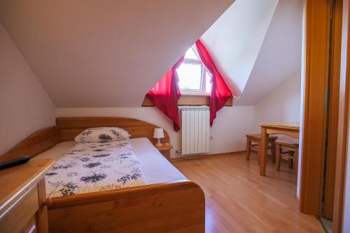 a small bedroom with a bed and a window at Domačija Malnarjevi in Villa Slavina