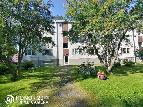 a large white building with bikes parked in the yard at Siisti valoisa kolmio in Lieksa