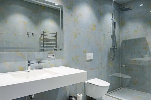 y baño con lavabo, aseo y ducha. en Roze Peldu Residence, en Liepāja