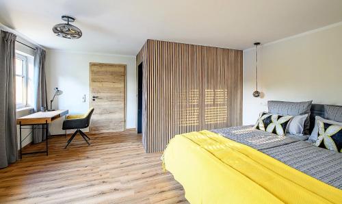 a bedroom with a yellow bed and a desk at Design Apartment an der Via Claudia 