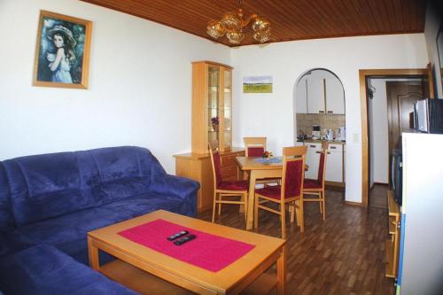 a living room with a blue couch and a table at Apartment in St Kanzian in a nice area in Srejach