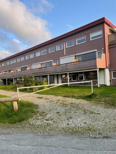 un grand bâtiment avec une clôture devant lui dans l'établissement Aurora Apartment very close to Fjellheisen, à Tromsø