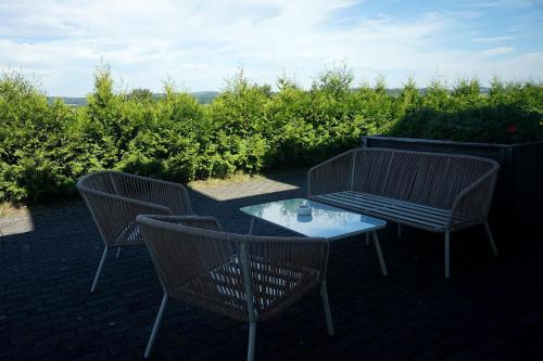 three chairs and a table on a brick patio at Hainberg Hotel Garni in Habrachćicy