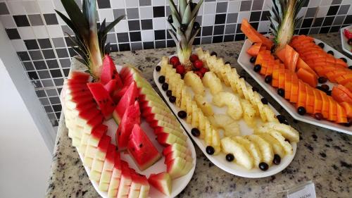 three plates of fruit and vegetables on a counter at Hotel Pousada Oasis in Conde