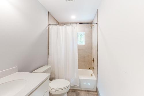 een witte badkamer met een toilet en een wastafel bij Town of Rehoboth Beach - 99 Sussex St Unit #2 in Rehoboth Beach