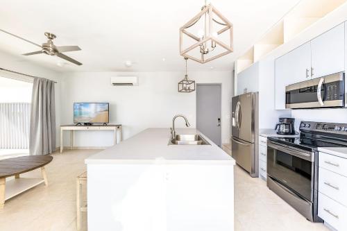 a kitchen with white cabinets and a counter top at NEW Tropical Waterfront Cooper Jack Bay Villas in Five Cays Settlement