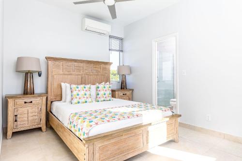 a bedroom with a wooden bed and a window at NEW Tropical Waterfront Cooper Jack Bay Villas in Five Cays Settlement