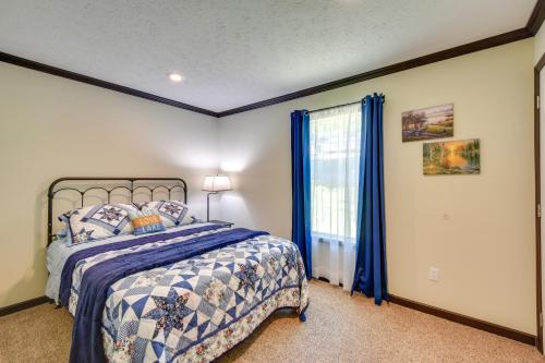 um quarto com uma cama com cortinas azuis e uma janela em Woodsy Hayesville Home on Jackrabbit Trail! em Hayesville
