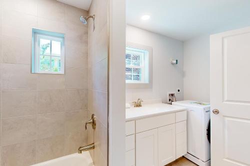 a white bathroom with a sink and a shower at Town of Rehoboth Beach - 99 Sussex St Unit #6 in Rehoboth Beach