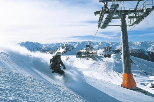 a man riding a snowboard down a snow covered ski lift at House in Krimml near Waterfalls & Hiking Trails in Krimml