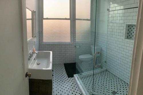 a bathroom with a shower and a sink and a toilet at 1940 Farmhouse with Pool in Newcastle