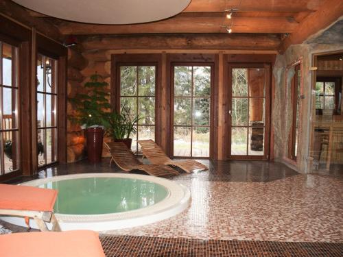 une baignoire jacuzzi dans une chambre avec fenêtres dans l'établissement Chalet in Bad Kleinkirchheim with 2 saunas, à Bad Kleinkirchheim