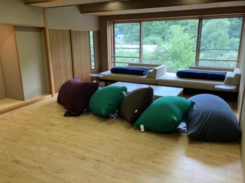 Oshuku Onsen Choeikan - Vacation STAY 55599v في Shizukuishi: غرفة مع مجموعة من الوسائد على الأرض
