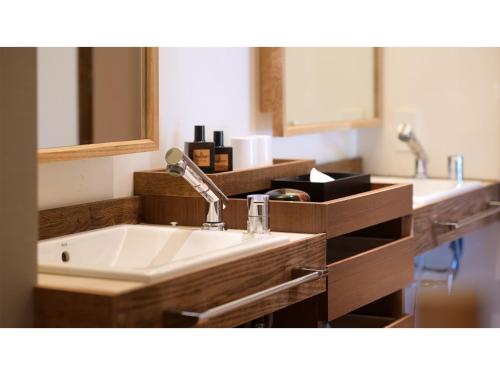 ein Bad mit einem Waschbecken und einem Spiegel in der Unterkunft Oshuku Onsen Choeikan - Vacation STAY 55599v in Shizukuishi