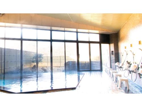 a pool in a building with large windows at Ashinomaki Prince Hotel - Vacation STAY 55298v in Aizuwakamatsu