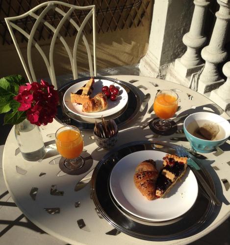 een tafel met twee borden eten en sinaasappelsap bij La Terrazza Vercelli Bed & Charme in Vercelli