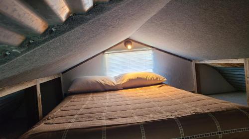Ce lit se trouve dans une petite chambre dotée d'une fenêtre. dans l'établissement Willow Beach RV Park & Marina, à Graford