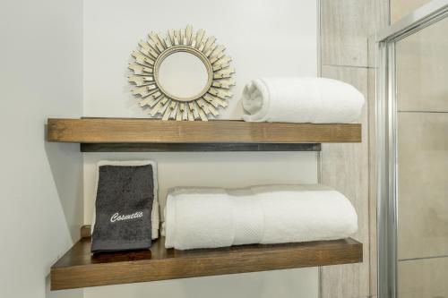 een badkamer met een plank met handdoeken en een spiegel bij 13 The Eero Room - A PMI Scenic City Vacation Rental in Chattanooga
