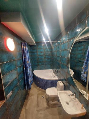 a bathroom with a tub and a toilet and a sink at Arnautskaya apartments in Odesa