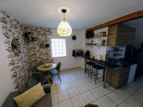 a kitchen and living room with a table and a counter at Le Passage Secret in Saint-Omer