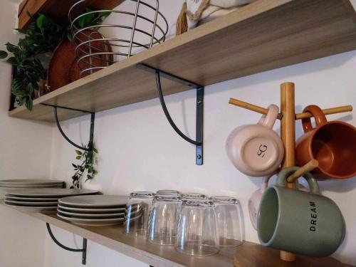 a shelf with dishes and utensils on it at Le Passage Secret in Saint-Omer