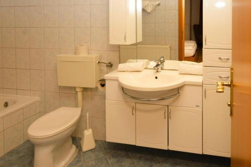ein weißes Bad mit einem WC und einem Waschbecken in der Unterkunft Apartment in Podersdorf am See with a bicycle storage in Podersdorf am See