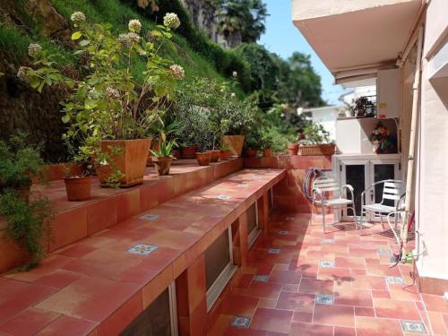 a patio with potted plants and a table and chairs at Piso con terraza junto a la playa in San Sebastián