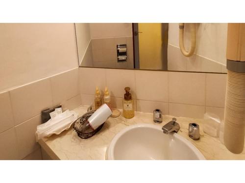 ein Bad mit einem Waschbecken und einem Spiegel in der Unterkunft ＨＯＴＥＬ ＰＯＳＨ - Vacation STAY 55613v in Odawara