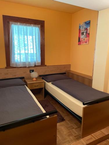 Duas camas num quarto com uma janela em Casa Federica em Valdidentro