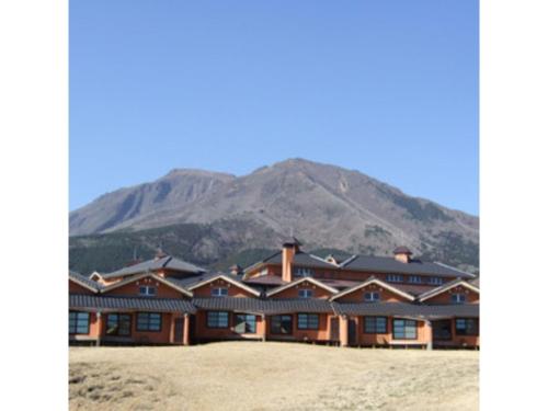 a large building with a mountain in the background at Resonate Club Shape - Vacation STAY 60134v in Taketa