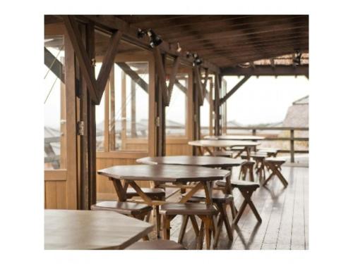 a row of wooden tables and chairs in a cafeteria at Resonate Club Shape - Vacation STAY 60135v in Taketa