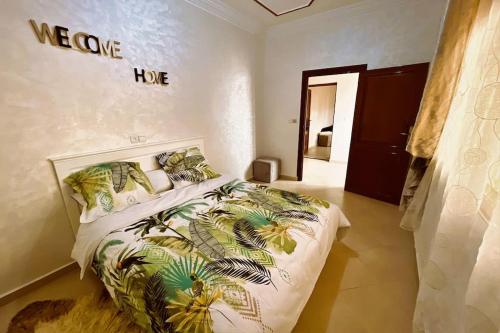 sypialnia z dużym łóżkiem z powitalnym znakiem na ścianie w obiekcie Magnifique Villa tout confort proche du Centre-ville w mieście Wadżda