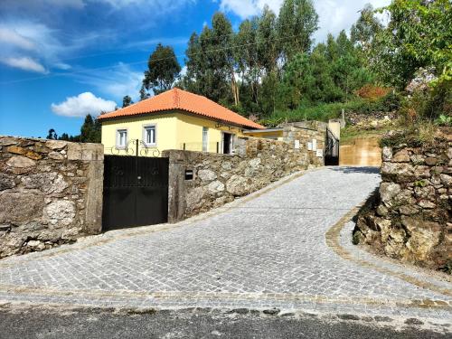 a driveway leading to a house with a gate at Casa Davó Cinda in Paredes de Coura