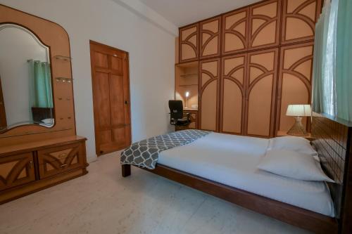 um quarto com uma cama grande e um espelho grande em HomeSlice Hangout em Bangalore