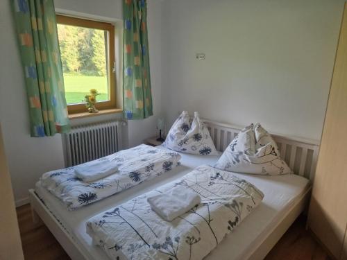 a bedroom with two beds with pillows and a window at Oase der Ruhe in Hollersbach im Pinzgau