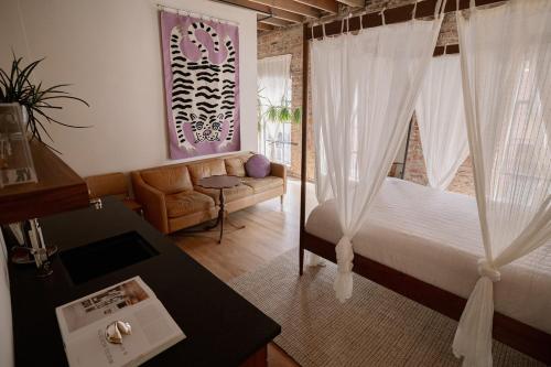 a bedroom with a bed and a couch and a table at Hotel No-Vacancy in Kansas City